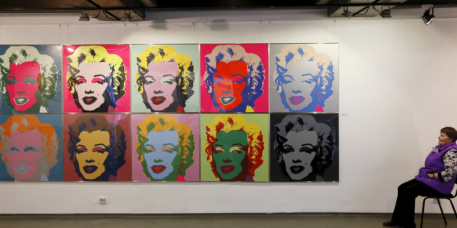 
A woman sits near the “Marilyn” print by pop artist Andy Warhol at the “The Square of the Peace” Museum Centre in Russia. | Reuters/Ilya Naymushin