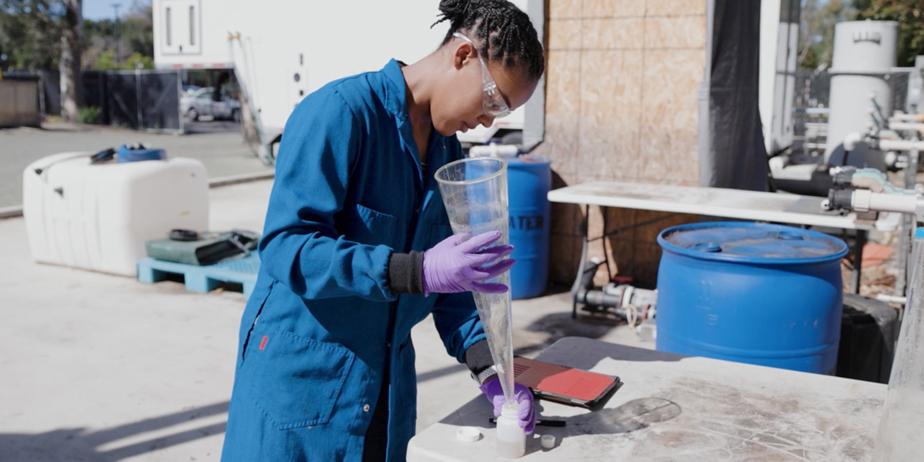 A woman taking a wastewater sample at a facility on the Stanford campus