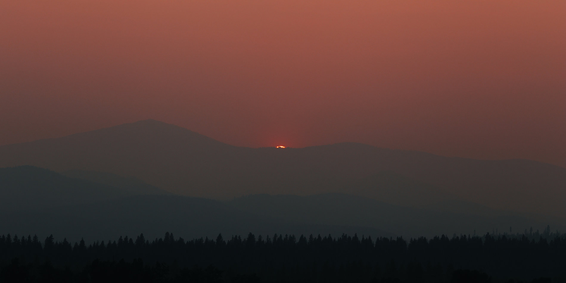 Photo of a smoky sunset in the mountains of northeastern Washington.