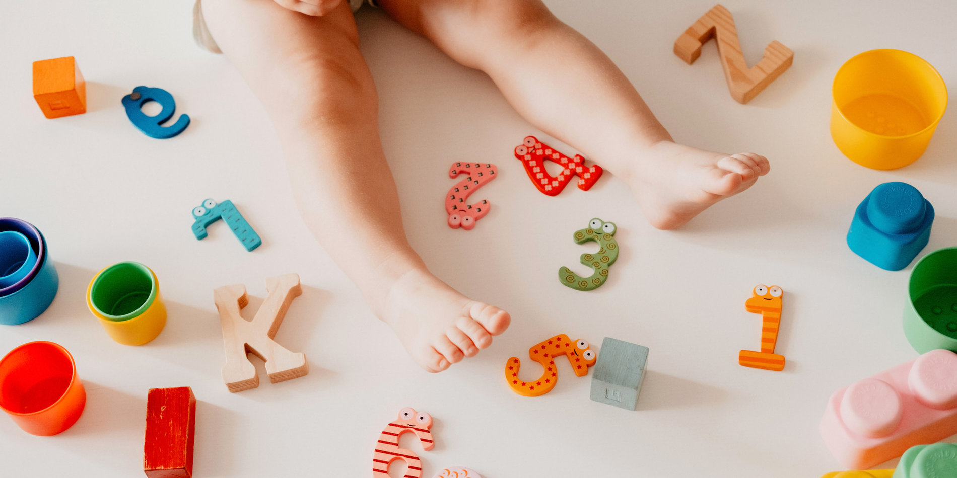 Top view of a baby’s legs with numbers and letters. 