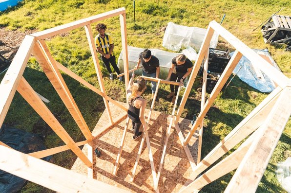 Looking down on three students putting together a wooden structure