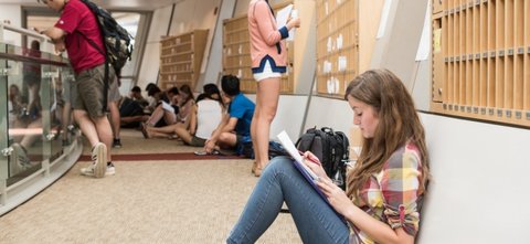 Students studying on floor in hallway