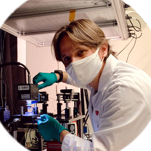 Ziv Lautman wearing a mask and gloves while working with a microscope