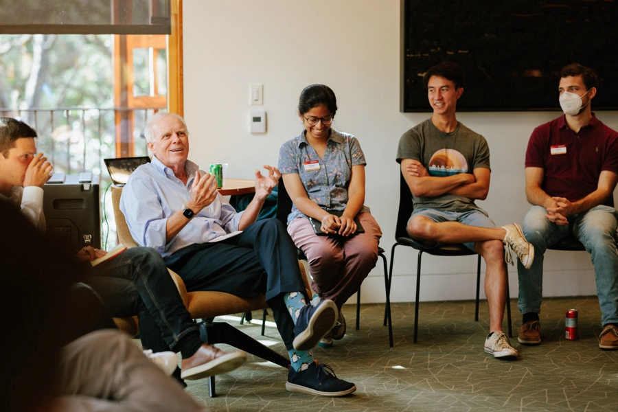 John Hennessy in conversation with a group of Knight-Hennessy scholars.
